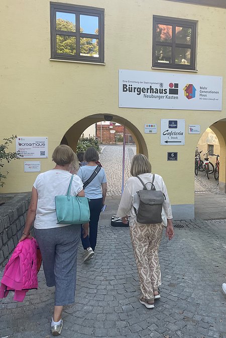 Rückansicht Teilnehmende am Engagement-Spaziergang vor dem Eingang des Bürgerhauses Neuburger Kasten